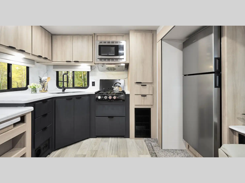 Winnebago Industries Towables Minnie Travel Trailer interior kitchen with stainless steel refrigerator and black cabinets